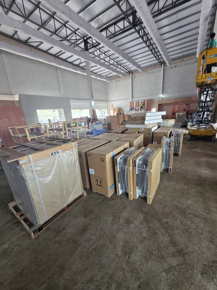 Large-scale commercial air-conditioning project site with pallets of units and equipment lift